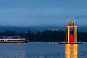 Ship on Lake Wolfgang with St. Wolfgang Advent Market and large floating lantern in the water.