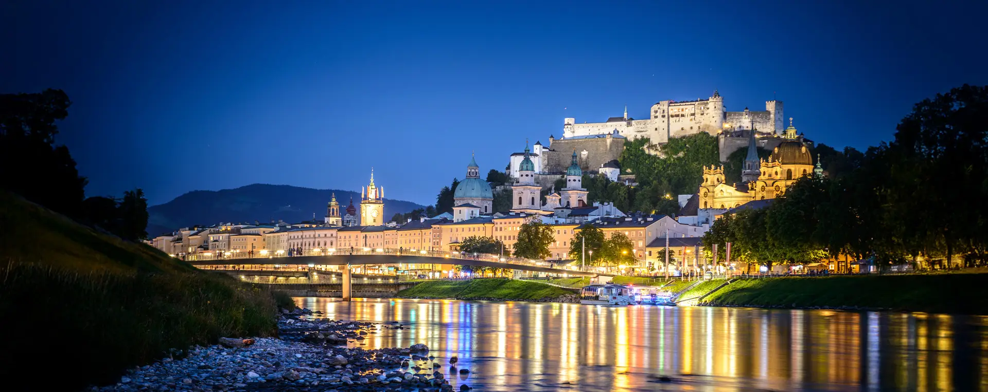 Night view of Salzburg’s historic Old Town with the illuminated fortress and churches during the Salzburg Night Tour.