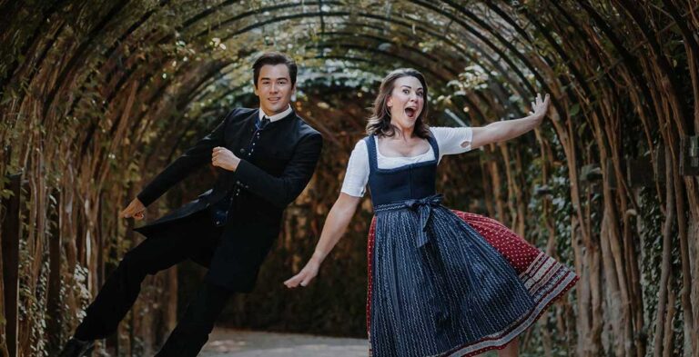 Two weTours Salzburg performers dancing and singing in a romantic garden tunnel in Salzburg