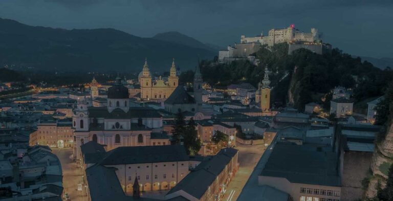 Night view over Salzburg Old Town with Hohensalzburg Fortress illuminated above the cit