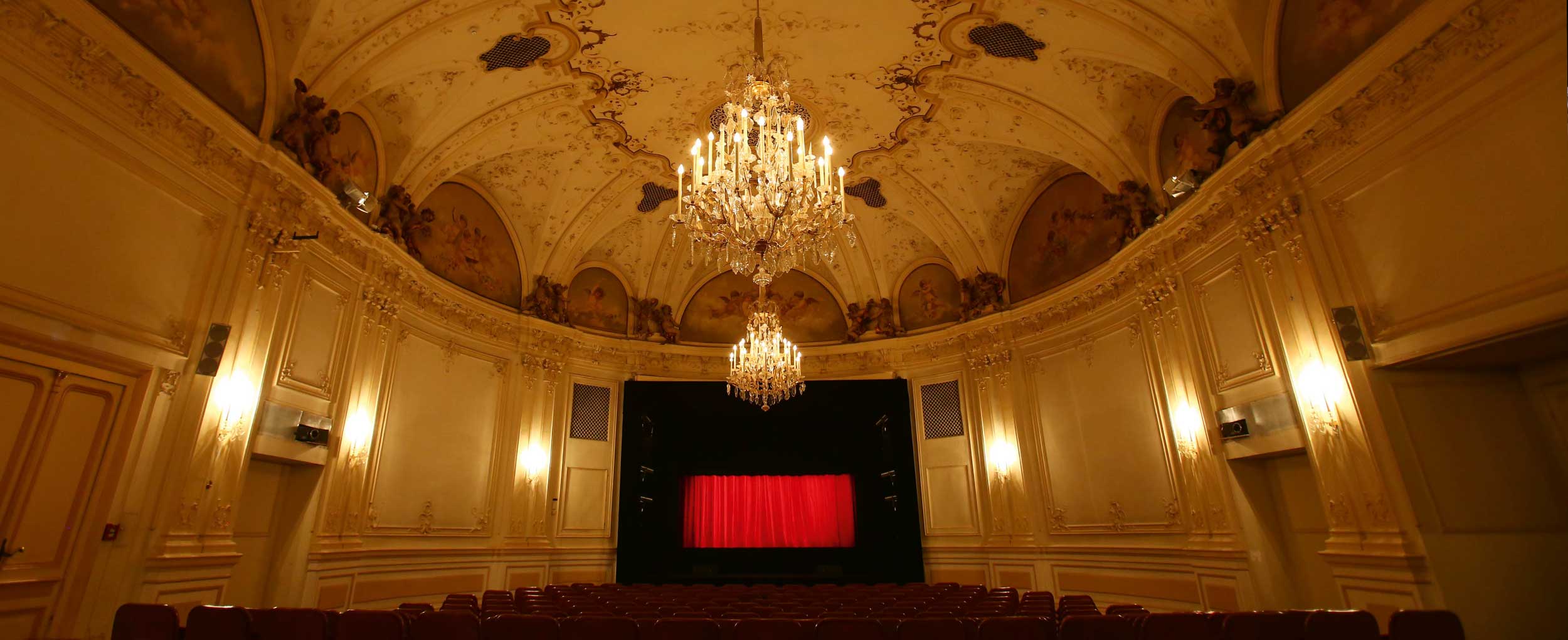 Interior of the historic Salzburg Marionette Theater with red curtain before the Sound of Music performance