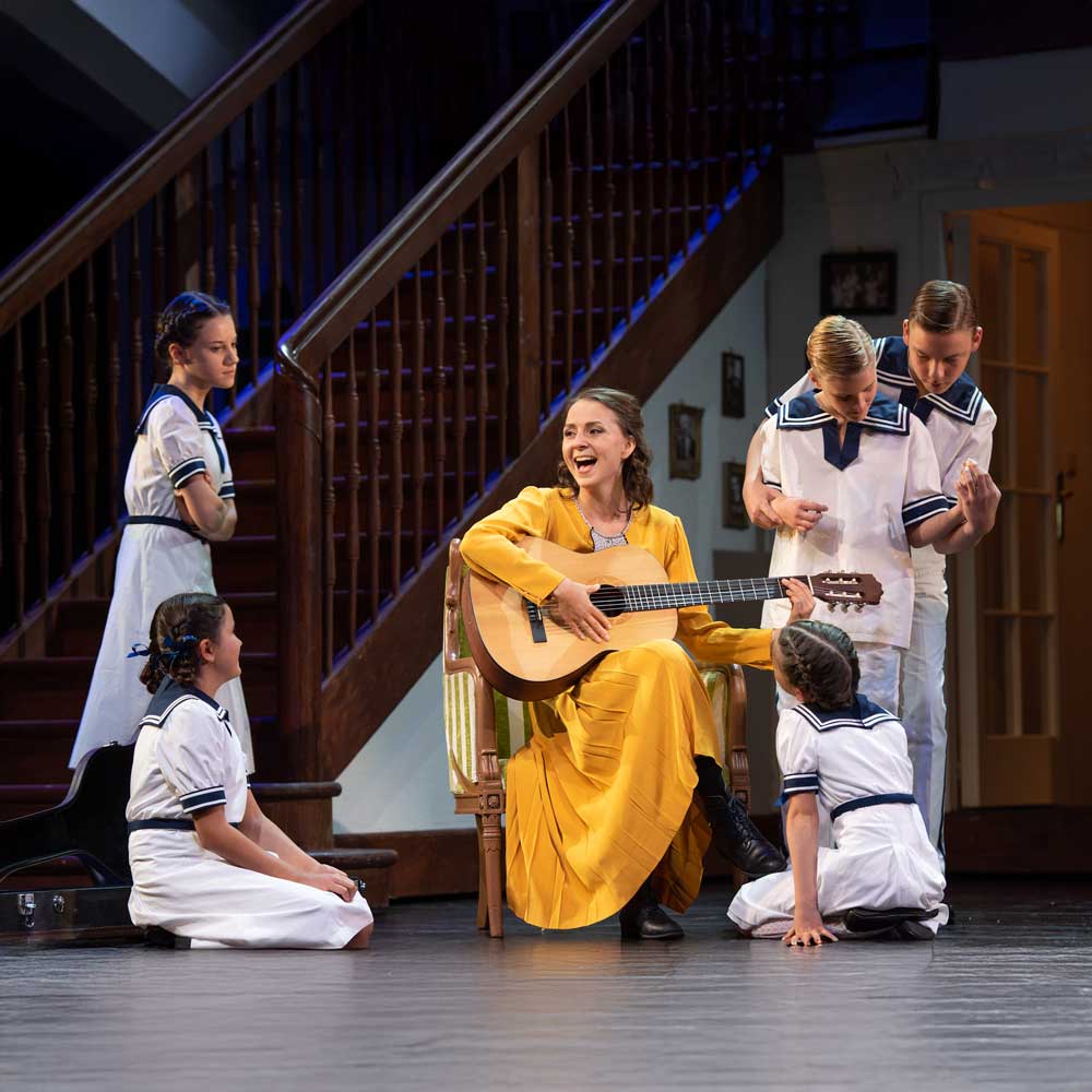 Sound of Music Salzburg featured image – Maria with guitar and von Trapp children at the State Theater