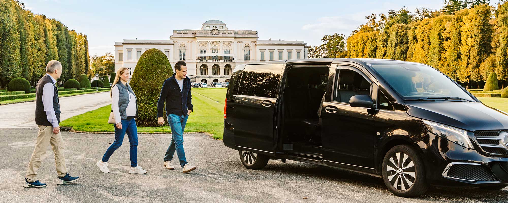 Luxury Tourism Salzburg – Private Arrival Experience Luxury tourism Salzburg – guests arriving for a private tour with a Mercedes V-Class at a historic palace garden.