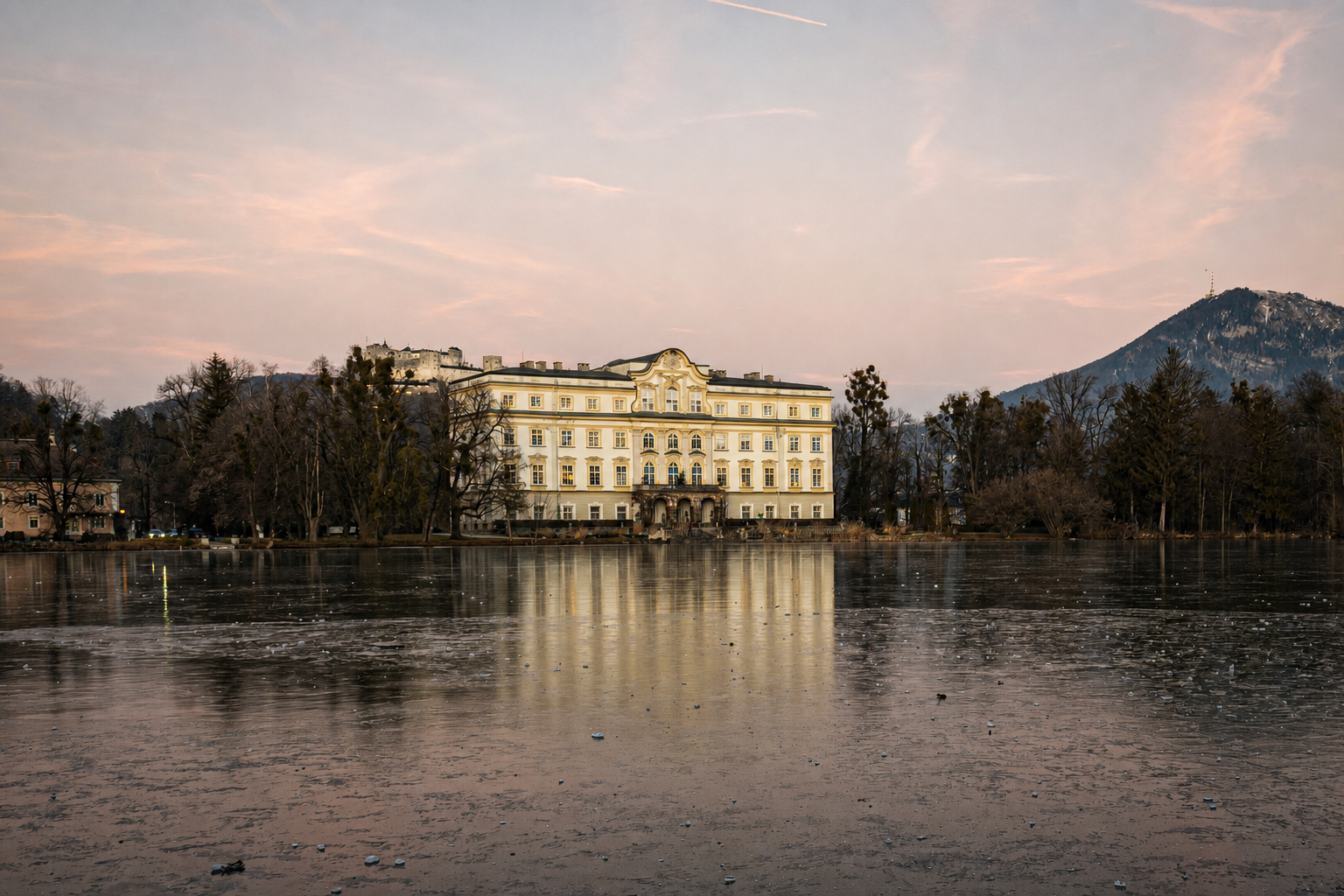 Leopoldskron Palace reflected on the frozen lake during winter in Salzburg.